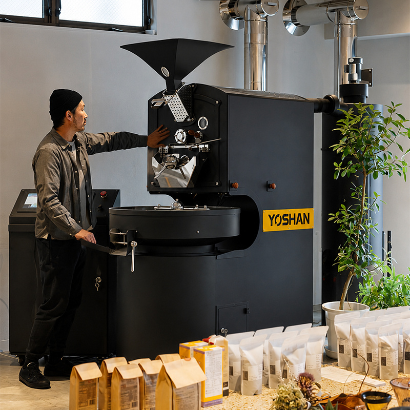 Barista operating a Yoshan coffee roaster in a cafe