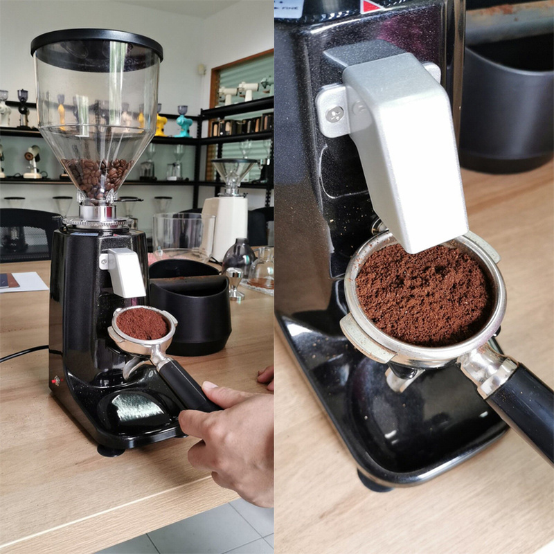 Flat burr grinder dosing ground coffee into a portafilter