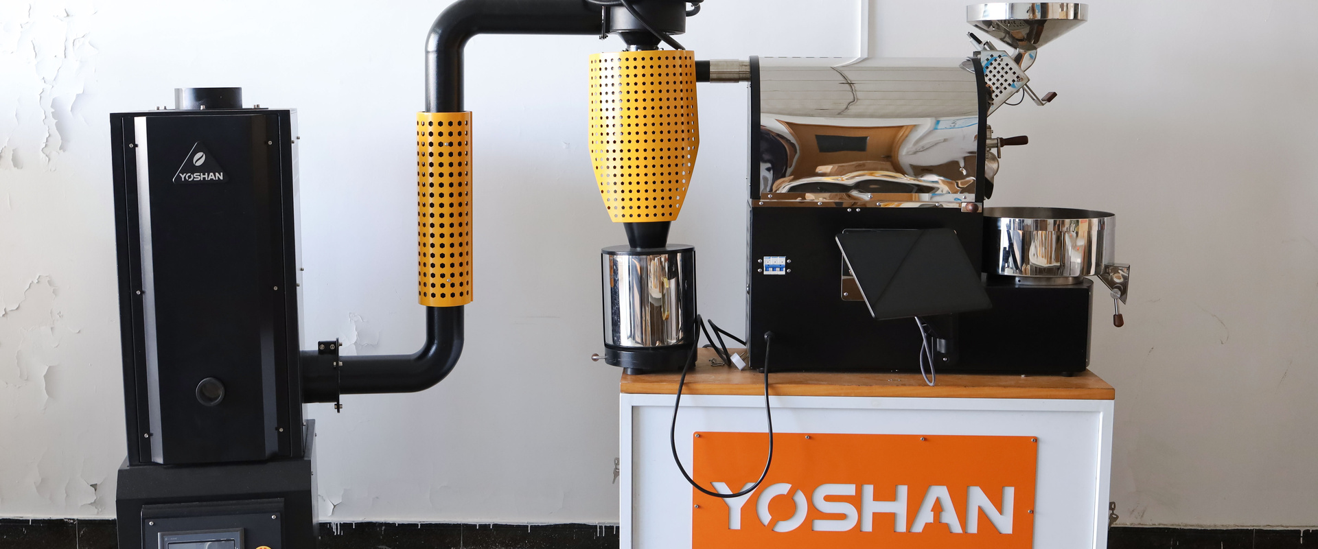 Yoshan SD-1.5 Pro coffee roaster with afterburner on a white factory wall