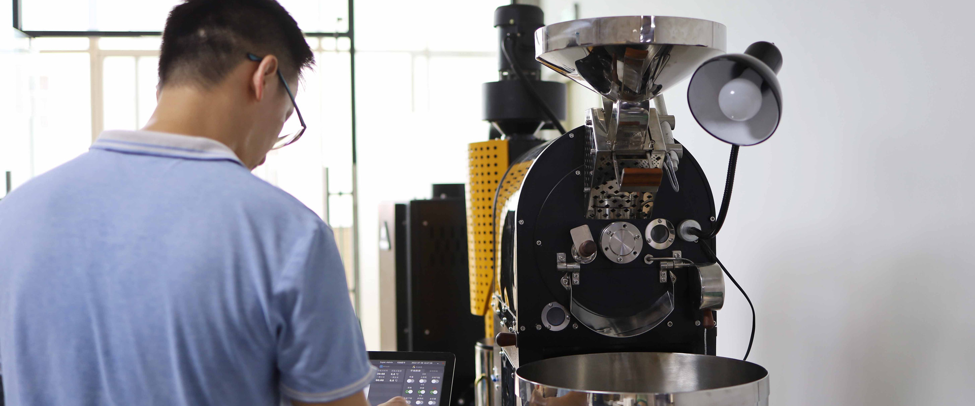 Yoshan technician test-roasting a machine in the factory before shipping